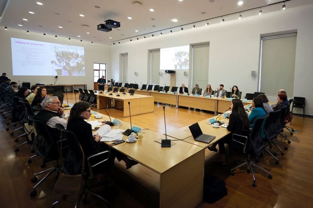 En la imagen podemos ver la Sala Valentín Letelier en la Casa Central de la U. de Chile con las/os participantes sentadas/os. 